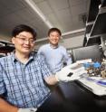 Zhen (Jason) He, assistant professor of civil engineering (left), and Junhong Chen, professor of mechanical engineering, display a strip of carbon that contains the novel nanorod catalyst material they developed for microbial fuel cells.