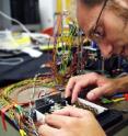 Georgia Tech Ph.D. candidate Joshua Schultz makes some final adjustments to the camera positioning mechanism used in the muscle-like cellular actuators of the robot vision system.