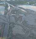 This is an aerial image of the extensive sand deposits in the Bonnet Carré Spillway, exposed after the water had drained and dried from the spillway following floods in 2011. Tire tracks near the bottom of the photo and a railroad track and trestle at the top of the photograph provide scale.