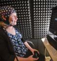 Monitored by electroencephalography (EEG) sensors, Sandia National Laboratories researcher Laura Matzen sits in a soundproof booth watching a screen that flashes words or images for one second. Matzen has been studying whether signals from the brain can predict whether people will remember something and whether training helps them remember.