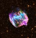 This highly distorted supernova remnant may contain the most recent black hole formed in the Milky Way galaxy. The composite image combines X-rays from Chandra (blue and green), radio data from the Very Large Array (pink), and infrared data from the Palomar Observatory (yellow). Most supernova explosions that destroy massive stars are generally symmetrical.  In the W49B supernova, however, it appears that the material near its poles was ejected at much higher speeds than that at its equator.  There is also evidence that the explosion that produced W49B left behind a black hole and not a neutron star like most other supernovas.