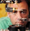 Georgia Tech assistant professor Alberto Fernandez-Nieves examines the experimental setup used to create toroidal droplets of nematic liquid crystal materials. The injection needle is shown above the cuvette containing the polymeric material, which rests on the rotation stage.