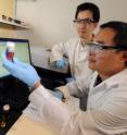 Georgia Tech professor Zhiqun Lin (standing) and research scientist Xinchang Pang compare two cadmium selenide (CdSe) nanocrystals made by Pang. The researchers are examining the absorption spectra of the nanocrystals in front of the computer.