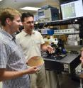 Members of the research team -- from left, Jeff Shainline, Milos Popovic and Mark Wade -- discuss the photonic-electronic microchip they developed.