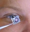 The iris component of the new imaging system, next to its human counterpart. The lens component is not pictured.