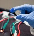 This prototype lithium ion battery, made in a Stanford lab, contains a silicon electrode protected with a coating of self-healing polymer. The cables and clips in the background are part of an apparatus for testing the performance of batteries during multiple charge-discharge cycles.