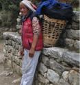 Sherpani is shown taking a rest along a trail at 3,800 m in the Khumbu District of Nepal and had carried loads to earn cash outside of the trekking season.