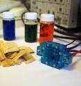 A new solar-induced direct biomass-to-electricity hybrid fuel cell can operate on a variety of fuels. The fuel cell, shown on the right, relies on a polyoxometalate (POM) catalyst (shown in the vials) which changes color as it reacts with light.