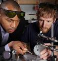 Assistant professor Baratunde Cola, from the George W. Woodruff School of Mechanical Engineering at Georgia Tech, and Ph.D. student Tom Bougher, show photoacoustic test equipment used to measure heat conductance of a new polymer material developed for thermal management.