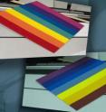 This is a rainbow pattern as seen under a long-linear, fluorescent light source common for commercial interiors (top). And, the same rainbow pattern as it appears under a non-commercial, fluorescent light source (bottom). The color differences result from the use of different phosphors in the lights glass tubing.