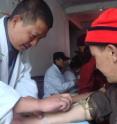 A Chinese researcher collects a blood sample from an ethnic Tibetan man participating in the DNA study.