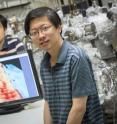 Yaoyi Li (foreground) and Mingxing Chen, UWM physics postdoctoral researchers, display an image of a ribbon of graphene 1 nanometer wide. In the image, achieved with a scanning-tunneling microscope, atoms are visible as "bumps."