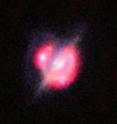 ALMA, the VLA, and other telescopes used gravitational lensing to obtain the best view yet of a collision that took place between two galaxies when the Universe was only half its current age. These new studies of the galaxy H-ATLAS J142935.3-002836 have shown that this complex and distant object looks surprisingly like the well-known local galaxy collision, the Antennae Galaxies. The foreground galaxy is doing the lensing and around it is an almost complete ring &#8212; the smeared out image of a star-forming galaxy merger far beyond. This picture combines the views from the Hubble Space Telescope and the Keck-II telescope on Hawaii (using adaptive optics) along with the ALMA images shown in red. The ALMA data also give information about the motions of the material in the distant merging galaxies and were vital in unravelling the complex object.