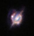 Using gravitational lensing, ALMA, the VLA, and many other telescopes obtained the best view yet of a collision that took place between two galaxies when the Universe was only half its current age. These new studies of the galaxy H-ATLAS J142935.3-002836 have shown that this complex and distant object looks surprisingly like the well-known local galaxy collision, the Antennae Galaxies. The foreground galaxy is doing the lensing and around it is an almost complete ring &#8212; the smeared out image of a star-forming galaxy merger far beyond. This picture combines the views from the Hubble Space Telescope and the Keck-II telescope on Hawaii (using adaptive optics).