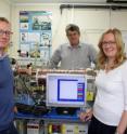 This image depicts from left to right Professor Andy Ellis, Professor Paul Monks and Dr Martha Clokie from the University of Leicester with the mass spectrometer.