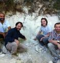 Left to right, Biaggio Giaccio, Gianluca Sotilli, Courtney Sprain and Sebastien Nomade sitting next to an outcrop in the Sulmona basin of the Apennines that contains the Matuyama-Brunhes magnetic reversal. A layer of volcanic ash interbedded with the lake sediments can be seen above their heads.