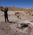 Threading temperature and pressure sensors down a geyser hole in the El Tatio region of Chile's Atacama desert.
