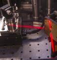 This photograph shows part of the two-dimensional infrared spectroscopy instrument operating in the laboratory of University of Chicago chemistry Chemistry Professor Andrei Tokmakoff. The normally invisible infrared laser beam appears red in this image with the aid of dry ice.