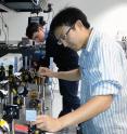 MIT's Sam Peng (foreground), and Paul Stevenson, a graduate student in chemistry at the University of Chicago, adjust the two-dimensional infrared spectroscopy system in the laboratory of Professor Andrei Tokmakoff.