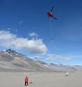A helicopter begins a survey with an airborne electromagnetic sensor at Bull Pass in the Wright Valley, McMurdo Dry Valleys, Antarctica.