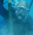Scientist Hannah Barkley collects coral skeleton cores using an underwater drill.