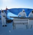 A freshly drilled ice-core from TUNU, Greenland containing a history of volcanic eruptions is pushed out of the core barell.