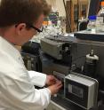 Georgia Tech postdoctoral fellow Jay Forsythe loads a sample into a mass spectrometer. The testing was done to see what compounds were formed by subjecting mixtures of amino and hydroxy acids to repeated wet-dry cycles.