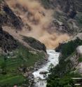 Ongoing debris fall mobilizing rock and dust from a landslide deposit due to the 2015 Gorkha, Nepal, earthquake (Mw 7.9). On the forefront (on the left), on the banks of the Upper Bhote Koshi river, collapsed houses and poles are visible, as well as other landslide deposits from the main shock and following aftershocks. This ongoing fall started without any determined trigger.