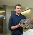 Dr. Rhodri Davies is pictured with volcanic rock.