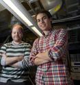 University of Chicago graduate students Andrew Yeats and Peter Mintum, with the fluoresent lights that led them to a surprising discovery at the Institute for Molecular Engineering.