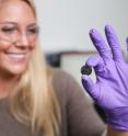 Vanderbilt graduate student Anna Douglas holding one of the batteries that she has modified by adding millions of quantum dots made from iron pyrite, fool's gold.
