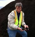 This is a picture of Chuck Rice, a Kansas State University professor, with a finished pile of compost made from food and yard waste.