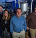 (L-R) Lab Director Jonathan Newport, Assistant Profs. Jessica Uscinski, Gregg Harry, and physics major Louis Gitelman stand in front of equipment that allows for testing properties of optics under actual conditions of LIGO detectors.