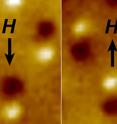 Magnetic microscope image of three nanomagnetic computer bits. Each bit is a tiny bar magnet only 90 nanometers long. The microscope shows a bright spot at the "North" end and a dark spot at the "South" end of the magnet. The "H" arrow shows the direction of magnetic field applied to switch the direction of the magnets.