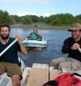 Daniel Nelson (left), Alyssa Atwood (center), and Simon Haberle of Australian National University  collect samples from a coastal lake on Isabela Island in 2008. The mangrove trees grow on the edge of the lake and their leaves are preserved in the sediment.