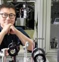 Prof. Oh-Hoon Kwon (School of Natural Science) is posing for a portrait with the ultrafast laser spectroscopy in the background.