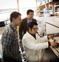 Ben Bunes (left), Ling Zang and Chen Wang (in lab coat), all researchers from the University of Utah's material sciences and engineering department, demonstrate a new prototype detector that can sense explosive materials and toxic gases. The research team developed a new material for the detector that can sense alkane fuel, a key ingredient in such combustibles as gasoline, airplane fuel and homemade bombs.