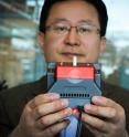 University of Utah materials science and engineering professor Ling Zang holds up a prototype handheld detector his company is producing that can sense explosive materials and toxic gases. His research team developed a new material for the detector that can sense alkane fuel, a key ingredient in such combustibles as gasoline, airplane fuel and homemade bombs.