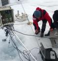Researchers service one of PROMICE's automatic weather stations on the Greenland ice sheet that was used in the study.