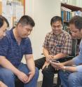 Part of the team members from NUS Nanoscience and Nanotechnology Institute are: (from left to right) Dr. Renshaw Wang, Dr. Huang Zhen, Assistant Professor Ariando and Professor T. Venkatesan. They are looking at a four-inch wafer on which a multi-component oxide film has been deposited using the pulsed laser deposition process.