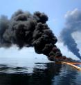 Dark clouds of smoke and fire emerge as oil burns during a controlled fire in the Gulf of Mexico, 6 May 2010. A new study found black carbon left from the burns joined a 'dirty blizzard' of contaminants that eventually settled on the seafloor.