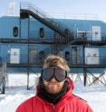 Morten Medici, Ph.D.-student at the Niels Bohr Institute is seen in front of the IceCube Lab at the South Pole, where the temperature can reach minus 70 degree Celcius, and some of the harshest winds blows. The IceCube Neutrino Observatory consists of 5,160 light sensors, frozen in the dark clear ice two kilometers beneath the surface. Here they detect the faint light from the ghost-like neutrinos. The signals from all the sensors are collected in the IceCube Lab, where the data is processed and transmitted via satellite to researches all over the world.