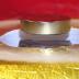 This image of a magnet levitated over a high-temperature superconductor array shows rectangular TFMs (black) levitating a heavy ferromagnet (silver) above a container of liquid nitrogen.