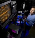 Sandia researcher Xinjian Zhou measures the electronic and optical properties of carbon nanotube devices in a probe station. The monitor shows the electrode layout on the device wafer; the nanotubes are positioned in the small horizontal gaps.