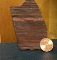 This image shows a close-up view of a field sample of 2.7 billion-year-old iron formation from Zimbabwe used in the study. The red color is caused by the iron oxide mineral hematite.