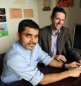 Researchers at Brigham and Women's Hospital (BWH) believe nanoparticles could prevent the itchy, red rash millions suffer from because they are allergic to the nickel found in many everyday objects. Here Praveen Kumar Vemula of BWH and Jeffrey Karp, co-director of the Center for Regenerative Therapeutics at BWH, sit next to a graphic describing their team's approach. Vemula holds a small jar representative of a cream containing the nanoparticles. He points to Karp's finger as an example of where the cream could be applied; many people are exposed to nickel through jewelry like rings.