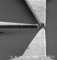 Scanned Electron Microscope image of a triode made from nanodiamond thin film that shows how the diamond components are cantilevered over a silicon dioxide substrate.