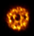 This is an ALMA image of the dust surrounding the star HD 107146. Dust in the outer reaches of the disk is thicker than in the inner regions, suggesting that a swarm of Pluto-size planetesimals is causing smaller objects to smash together. The dark ring-like structure in the middle portion of the disk may be evidence of a gap where a planet is sweeping its orbit clear of dust.