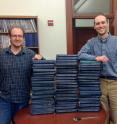 Prof. Jonathan Payne (right) and Noel Heim, a postdoctoral researcher in Payne's lab, stand next to stacks of the Treatise on Invertebrate Paleontology, which they recently used to provide fresh evidence of Cope's rule.