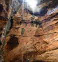 Abseiling into Natural Trap Cave, Wyoming, is shown. Alan Cooper descending the 100ft pitch into NTC to excavate Ice Age megafaunal bones.